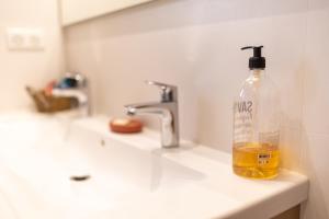 a bottle of soap sitting on top of a sink at Aux coquelicots sauvages in Pont-Saint-Martin