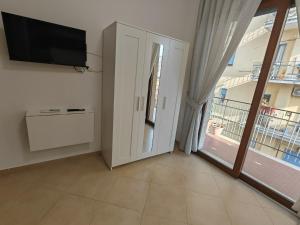 a living room with a tv and a large window at B&B Estia Domus in Pompei