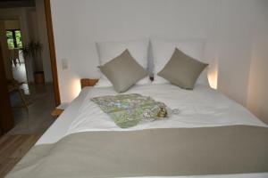 施莱登Gästehaus Eifelsteig的一张白色的床,上面有枕头