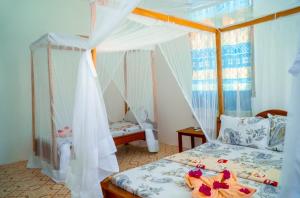 a bedroom with a bed with a canopy at Saba House 24 in Paje