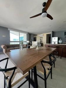 ヌエボ・バジャルタにあるDepartamento Frente al Mar Ariaのダイニングルーム(椅子、シーリングファン付)