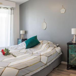 Un dormitorio con una cama con una almohada verde y una ventana en T2 Plage Prado-David, Parc Borély, Parking Privée, en Marsella