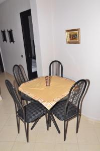 a dining room table with four chairs and a yellow table at Appartement au coeur de Fès in Fès