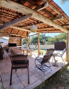 a patio with chairs and a table under a pergola at Camping Urbano La Casita in Pedreiras