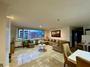 a living room with a couch and a table at Departamento de Lujo, Cuenca, Adrianashome in Cuenca