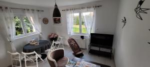a living room with a table and chairs and a television at Breizh Villa in Landivisiau