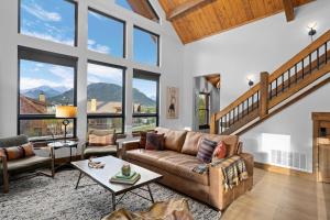 a living room with a couch and a table at Beautiful Views! Jacuzzi, Indoor/ Outdoor Fireplace, Steps to Lake Estes in Estes Park