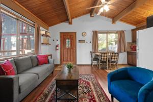 a living room with a couch and a table at Cute Cozy Cabin - Nestled in the quiet neighborhood of Sugarloaf. in Sugarloaf
