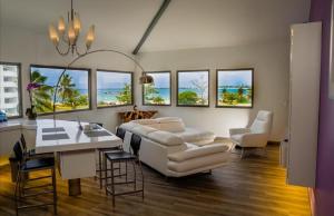 Una sala de estar con un sofá, una mesa y sillas. en Commodore Suites, SureStay Collection by Best Western, en Simpson Bay