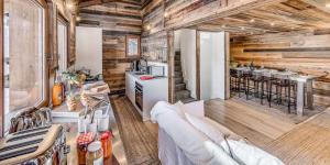 a living room with wooden walls and a kitchen at Chalet Paradis Blanc - Chalet 4 - 129m2 - 6 chambres, 6 salles de bain MAE-2024 in Tignes +24 photos