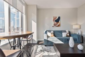 a living room with a blue couch and a table at Bright & Modern Apt Downtown Seaport in Boston