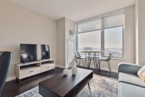 a living room with a television and a table with chairs at Bright & Modern Apt Downtown Seaport in Boston