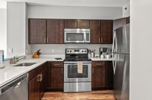 a kitchen with stainless steel appliances and wooden cabinets at Modern Apt Near Downtown in White Plains
