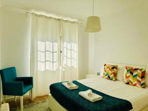 une chambre avec un lit et une chaise bleue dans l'établissement GLICINIAS Cascais Villa, à Birre 71 autres photos