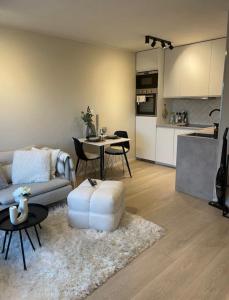 a living room with a couch and a table and a kitchen at Plaza Havstad in Trondheim +11 photos