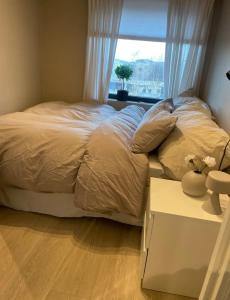 a bedroom with a large bed with a window at Plaza Havstad in Trondheim