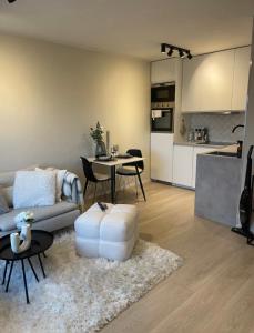 a living room with a couch and a table and a kitchen at Plaza Havstad in Trondheim