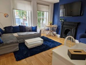 ein Wohnzimmer mit Couch und Kamin in der Unterkunft HU1 Hull City Centre Modern Apartment WIFI BATH H9 in Hull