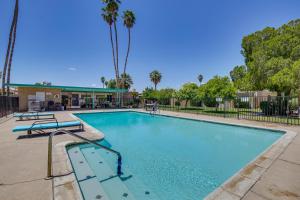 a swimming pool at a resort with palm trees at Centrally Located Yuma Retreat with Fenced Patio in Yuma