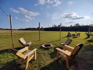 a group of chairs and a fire pit in a field at Rustic Country Retreat With Private Sauna in Leie