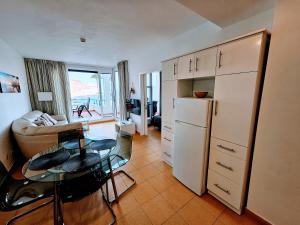 a living room with a white refrigerator and a table at Wonderful Ocean View in Playa del Cura