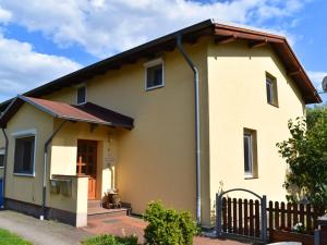 una pequeña casa amarilla con techo marrón en Behagliche Ferienwohnung im idyllischen Körchow, en Körchow