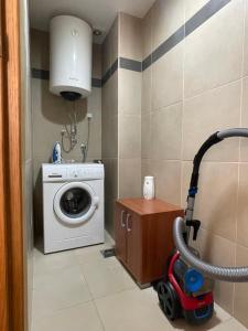 a bathroom with a washing machine and a vacuum at Sunset Poolside Retreat BlueH in Budva