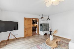 a living room with a flat screen tv and a table at Casa Primavera - große Stadtvilla im Zentrum Miesbachs in Miesbach