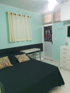 ein Schlafzimmer mit einem Bett, einem Schreibtisch und einem Tisch in der Unterkunft Apartamento Bangalo Cabo Frio in Cabo Frio + 47 Fotos