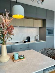 a kitchen with a table and a vase with a plant at Rooftop Apartment,Business trip,Fast Internet in Schönefeld +7 photos