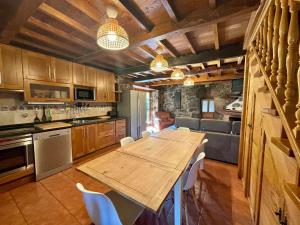 a large kitchen with a wooden table and chairs at La Fontina de Tene in Tene