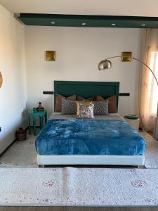 a bedroom with a large bed with a blue blanket at VILLA De LUXE in Marrakesh +6 photos