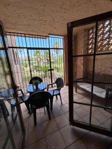 a room with a table and chairs and windows at Aires de la Bahia in San Fernando
