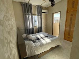 ein Schlafzimmer mit einem Bett in einem Zimmer mit einem Fenster in der Unterkunft Housse Fez City in Fès