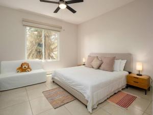 a white bedroom with a bed and a teddy bear on a couch at Luxury 3 Bedroom apartment in Río Hato