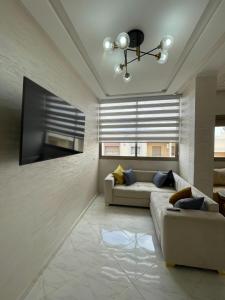ein Wohnzimmer mit Couch und großem Fenster in der Unterkunft Housse Fez City in Fès + 2 Fotos