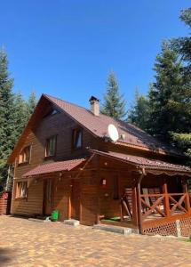 a large wooden house with trees in the background at Ялинка in Migovo