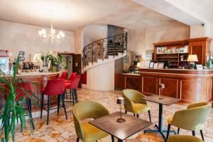a restaurant with chairs and tables and a bar at Hotel Eden Salò in Salò
