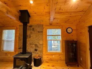 une cheminée dans une pièce en bois avec une horloge au mur dans l'établissement Luxury Forest Lake House - Privacy, Nature, Conveniences - New 2 bedroom, à Windsor