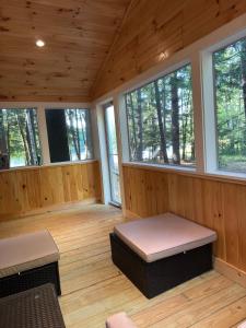- une chambre avec des murs en bois et des fenêtres dans une cabine dans l'établissement Luxury Forest Lake House - Privacy, Nature, Conveniences - New 2 bedroom, à Windsor