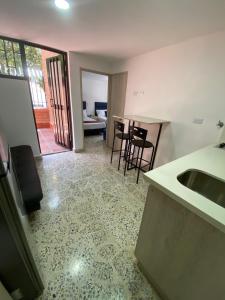 a kitchen with a sink and a table with chairs at Céntrico Familiar Vive y disfruta Medellín 107 in Medellín