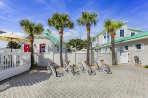 four bikes parked in front of a fence with palm trees at Island Cottage Inn in Flagler Beach