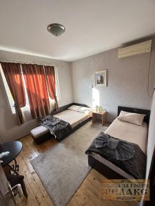 una camera d'albergo con due letti e una finestra di Къща за гости Рупите , Guest House Relax Rupite a Rupite Altre 58 foto