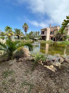 a house and a pond in front of a building at Aires de la Bahia in San Fernando
