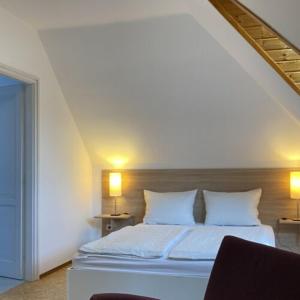 a bedroom with a bed with white sheets and pillows at Greenhouse Apartman in Zalakaros