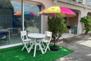 a table and chairs and an umbrella on a lawn at Studio avec vue in Belley