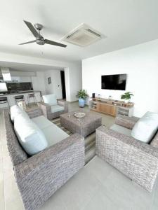 ein Wohnzimmer mit Sofas und einem Flachbildfernseher in der Unterkunft Espectacular Apartamento 211 M2, Playa Dormida Dos in Playa Dormida