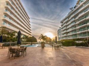 eine Terrasse mit Tischen und Stühlen neben einem Gebäude in der Unterkunft Espectacular Apartamento 211 M2, Playa Dormida Dos in Playa Dormida