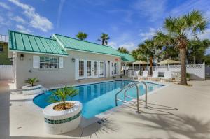 a swimming pool in front of a house at Island Cottage Inn in Flagler Beach