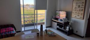 a living room with a table and a television at Residencia Merlo in Rafaela